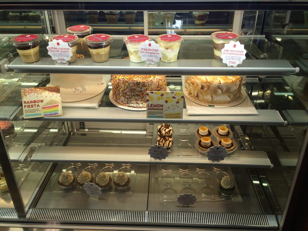 Display case with custom cakes, cupcakes, and desserts